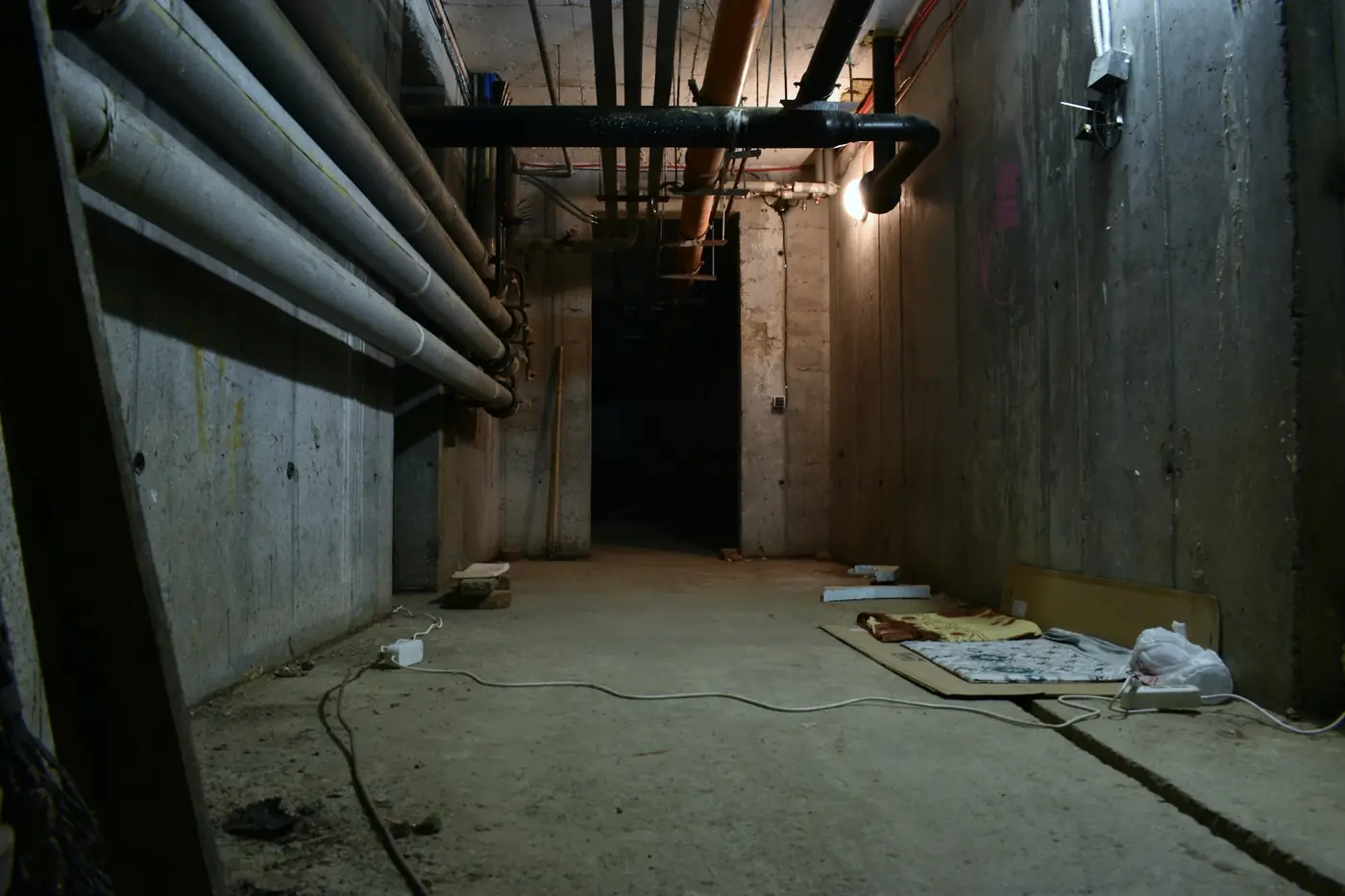 Unfinished basement with water pipes, where a sump pump keeps groundwater out