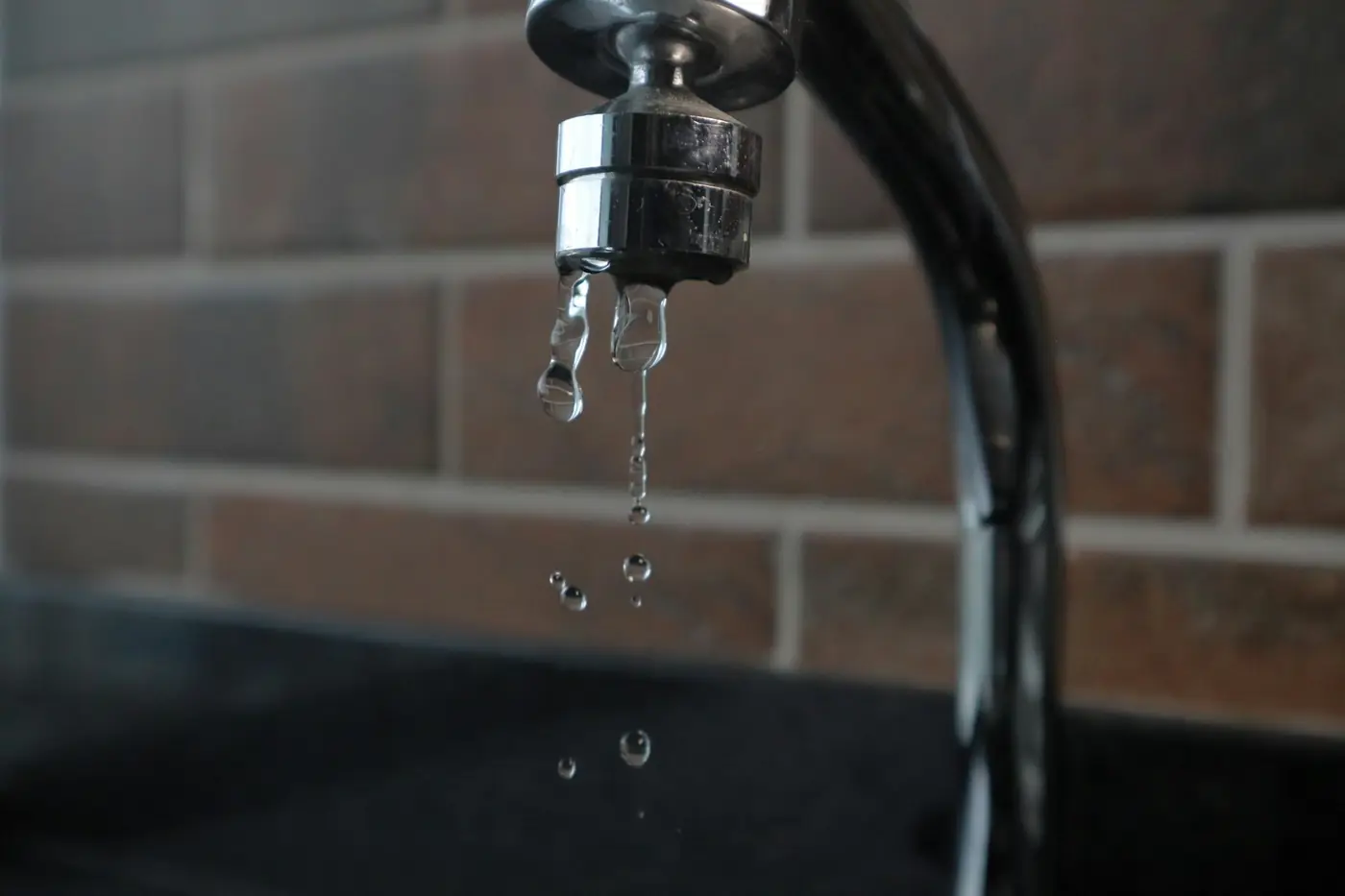 Kitchen faucet dripping water, a sign of a worn cartridge or washer