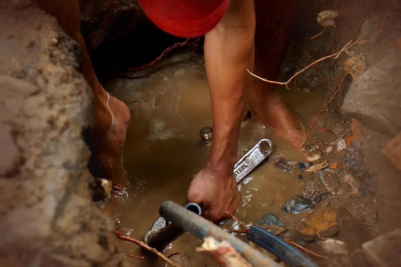 Plumber repairing a broken water pipe in an emergency
