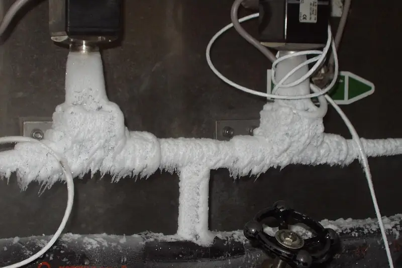 Frost covering water pipes in a cold space