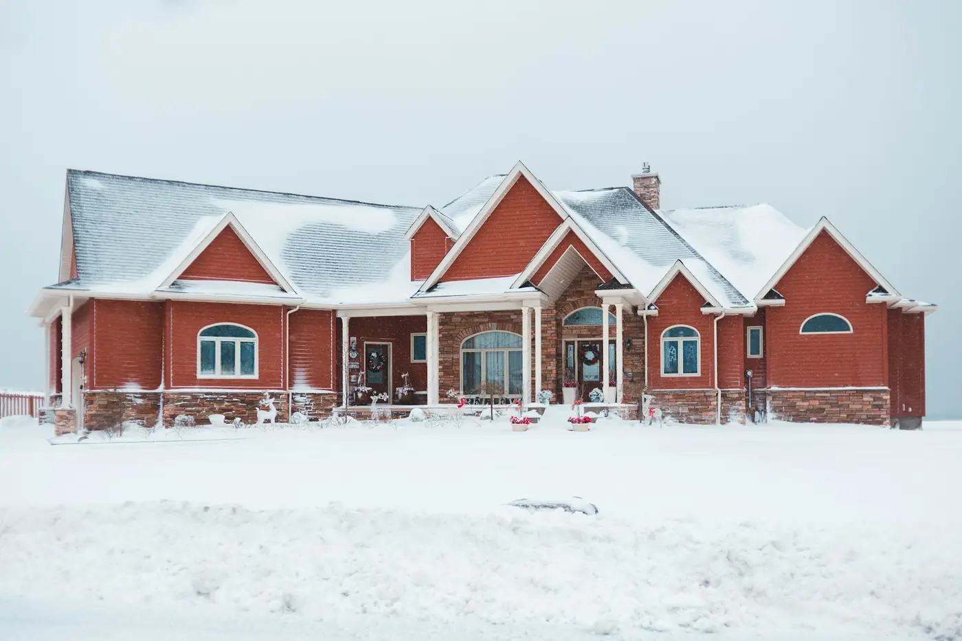 Red and gray house in deep snow on a winter day