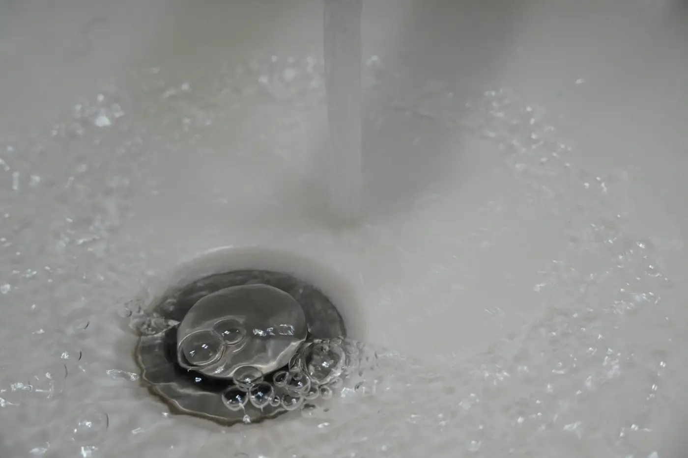Water swirling down a sink drain after a clog was cleared
