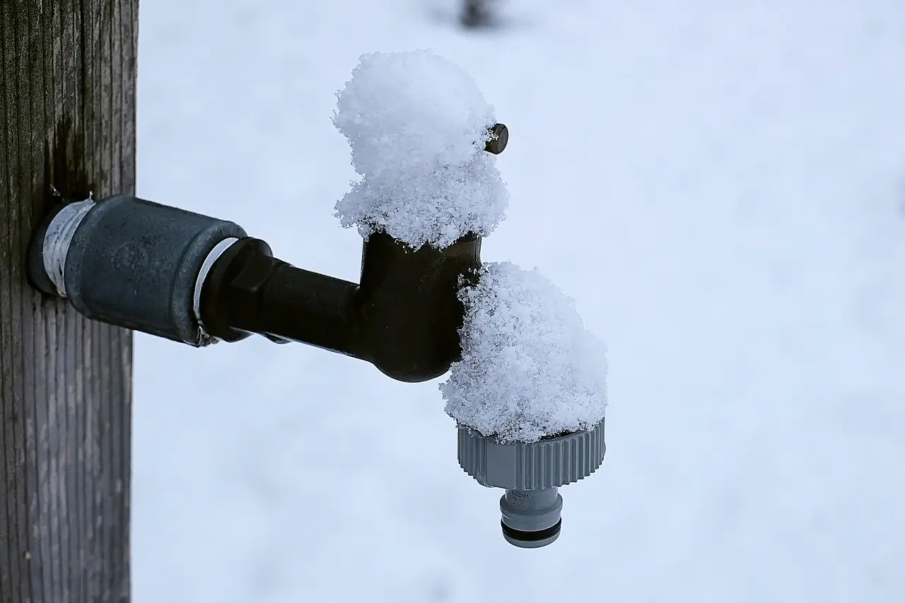 Outdoor faucet covered in snow in winter