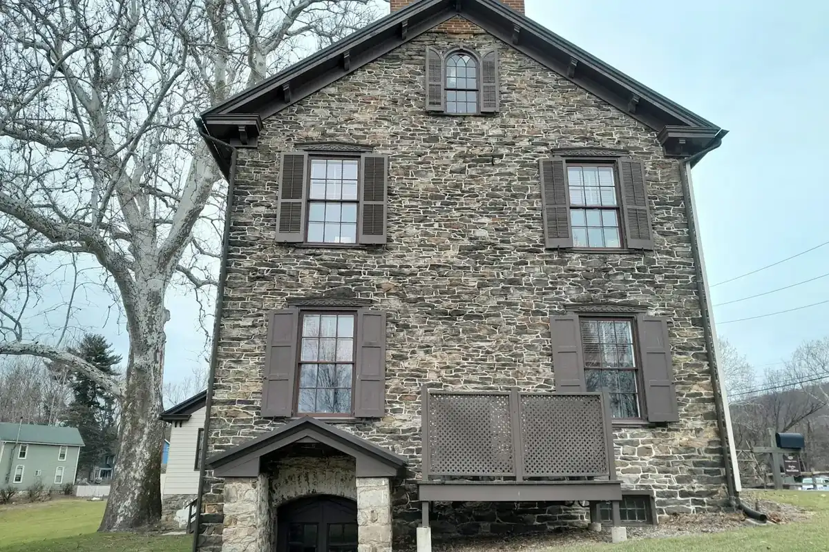 Tall stone house with shutters on a clear winter day