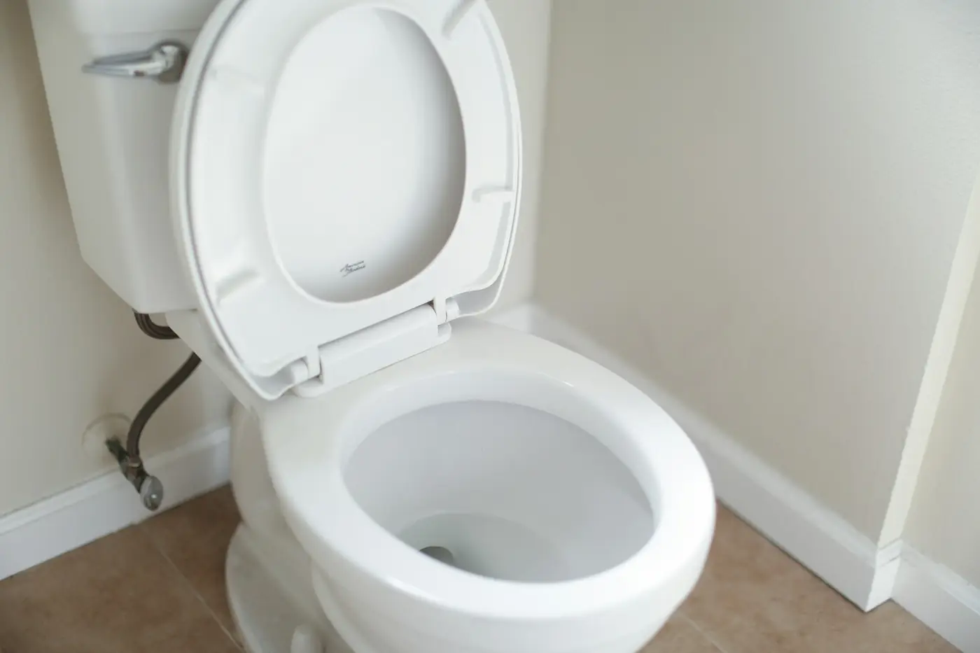 White toilet with the seat lifted, ready for repair