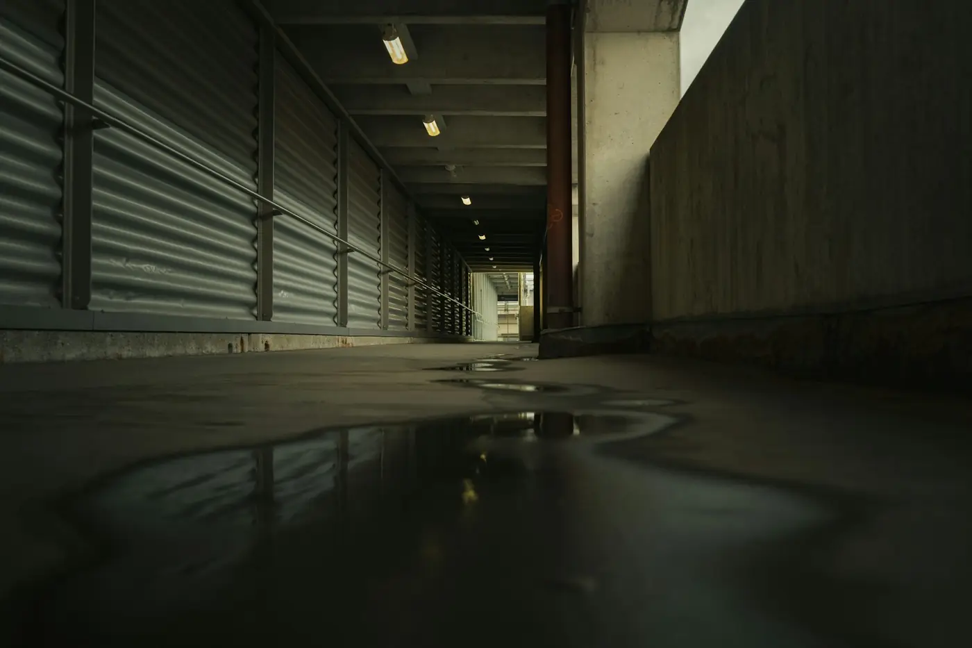 Puddle of water spreading across a floor from a leak